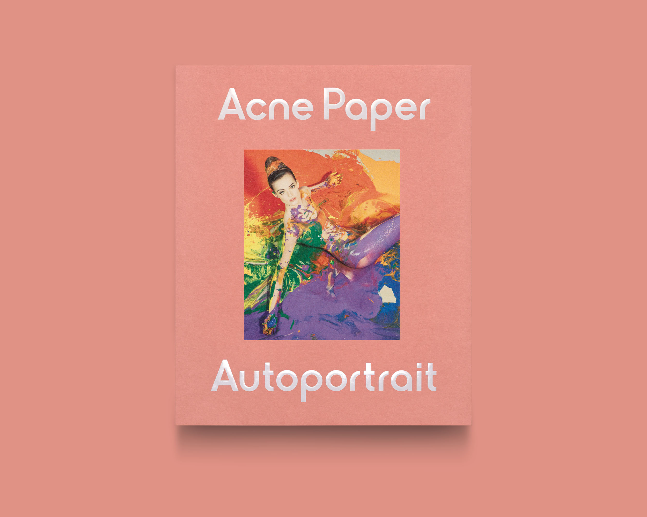 Acne Paper Autoportrait issue with a salmon-pink cover featuring a central photograph surrounded by multicoloured paint.