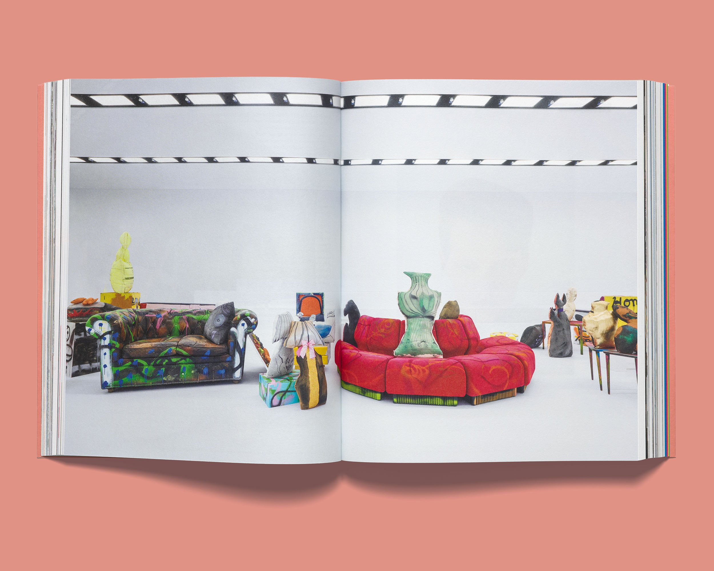 Open Acne Paper displaying a double-page spread photograph of colorful art installations and decorated furniture in a white studio space.